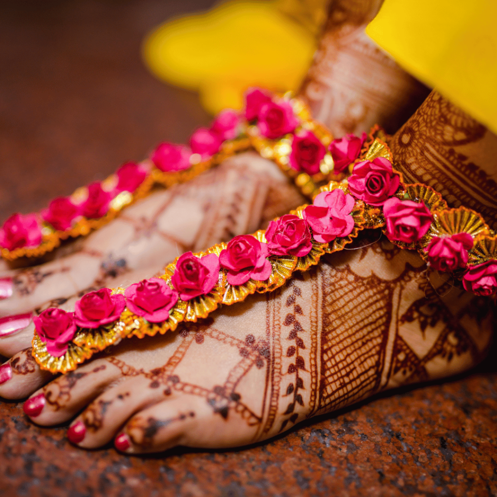 Bride on its mehndi event waring flower shoes with henna applied in elegant way.