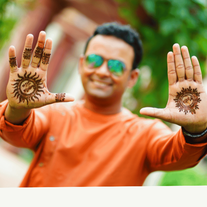 Men showing mehndi designs on his both hands